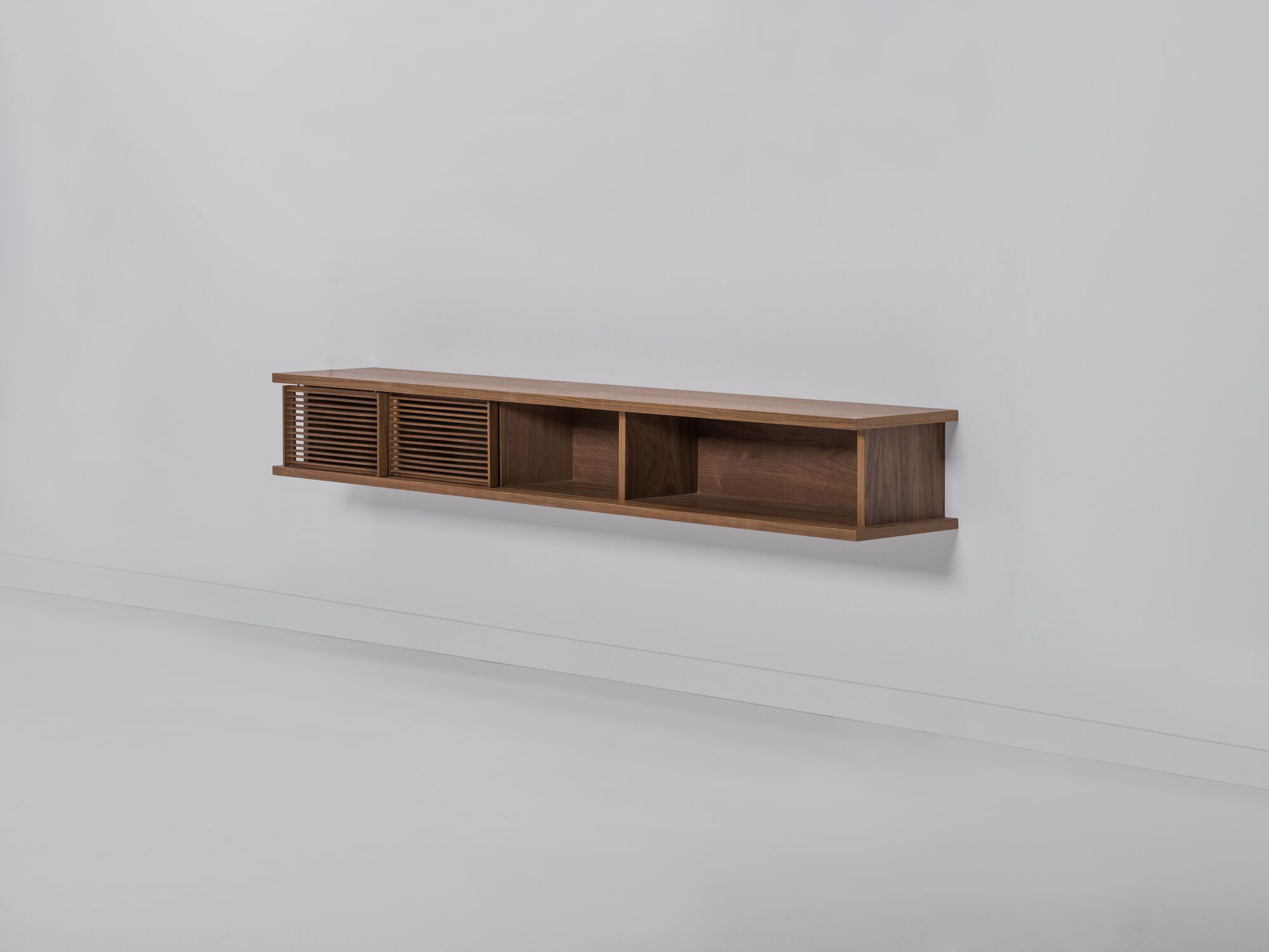 Large walnut floating media unit with slatted doors front angle view